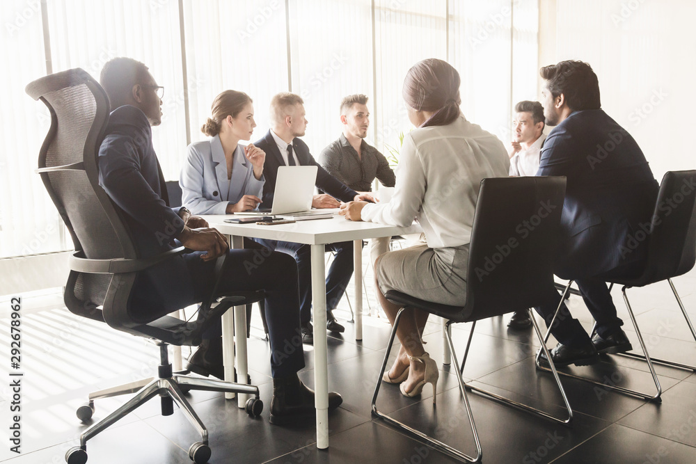 Silhouettes of people sitting at the table. A team of young businessmen working and communicating together in an office. Corporate businessteam and manager in a meeting