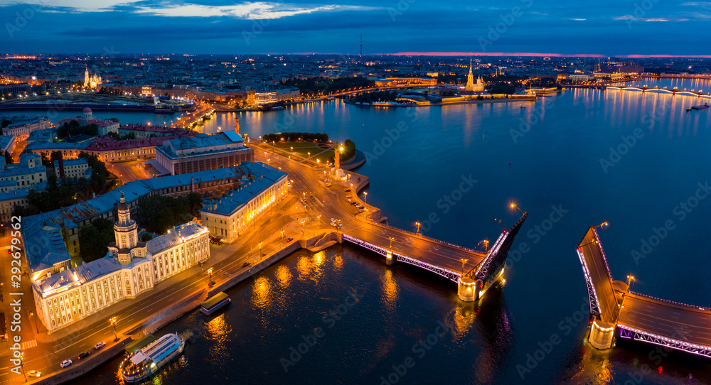 Fototapeta premium Panorama of evening Saint Petersburg from a height. Bridges Of St. Petersburg. Rivers Of St. Petersburg. Palace bridge across the Neva divorced. Vasilievsky island in the evening lights.