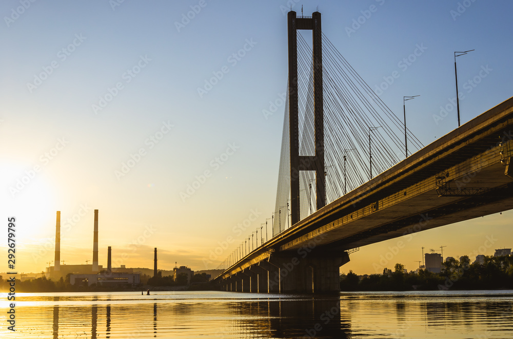 South bridge, Kyiv, Ukraine. Kyiv bridge over the Dnipro river against the backdrop of a beautiful sunset. The bridge in the evening sun South bridge, Kyiv, Ukraine. Kyiv bridge over the Dnipro river against the backdrop of a beautiful sunset. The bridge in the evening sun