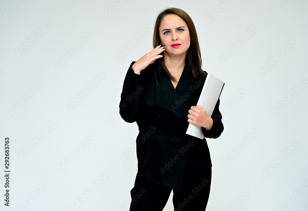 Portrait on a white background of a pretty adult executive brunette woman in black business suit. Serious business look and communication. Portrait on a white background of a pretty adult executive brunette woman in black business suit. Serious business look and communication.