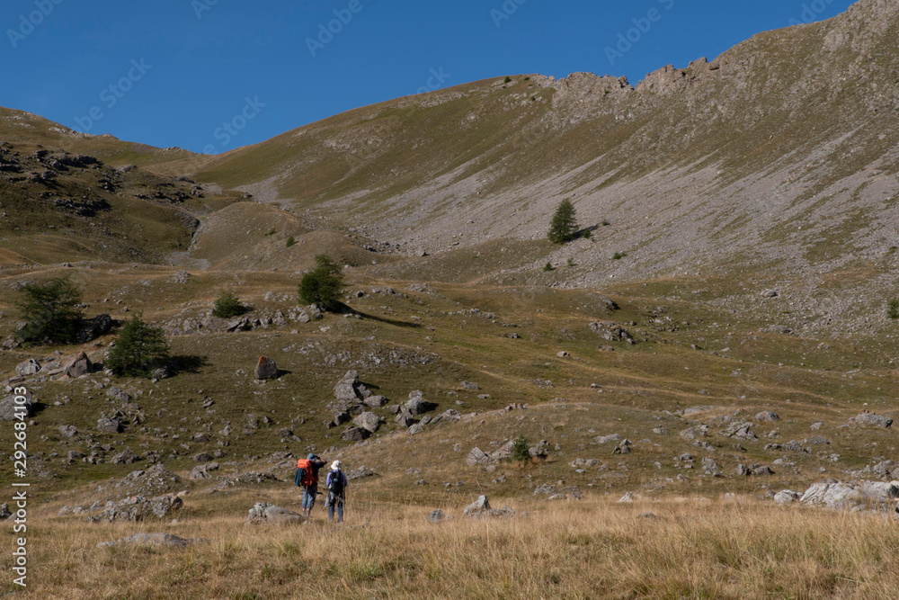Hiker and mountain landscape in summer in the French Alps