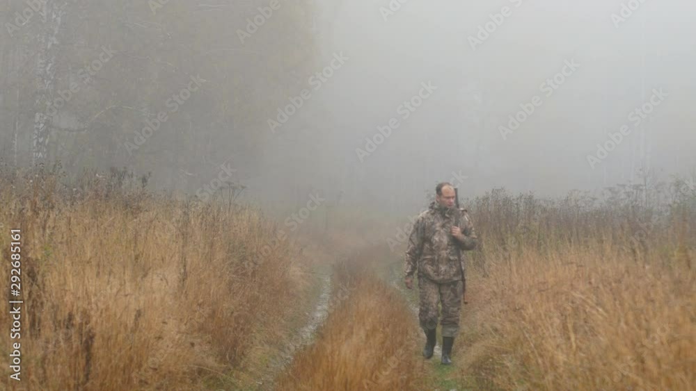 The hunter is on the road. Early morning, fog. Autumn, yellow grass along the road. The hunter is on the road. Early morning, fog. Autumn, yellow grass along the road.