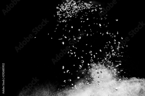 Launched white powder white small stones splash on black background.