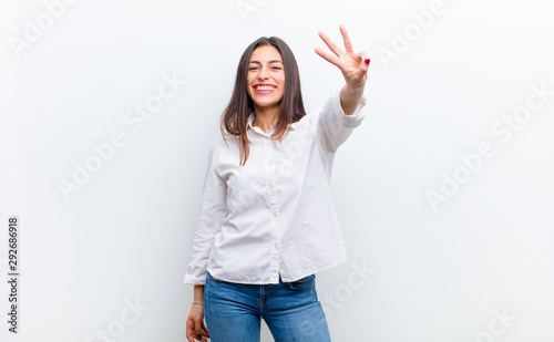 Obraz na płótnie young pretty woman smiling and looking friendly, showing number three or third w