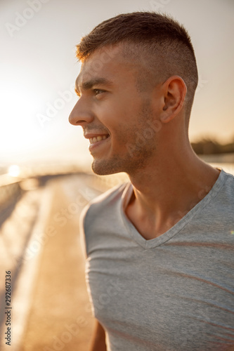 Smiling sportive young man looking into the distance