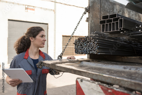 Woman looking construction iron on truck photo