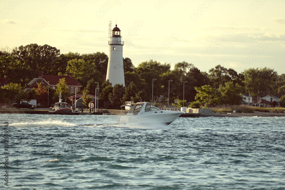 powerboat by lighthouse on the river