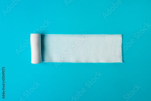 Fotografía Medical bandage untwisted on a blue background