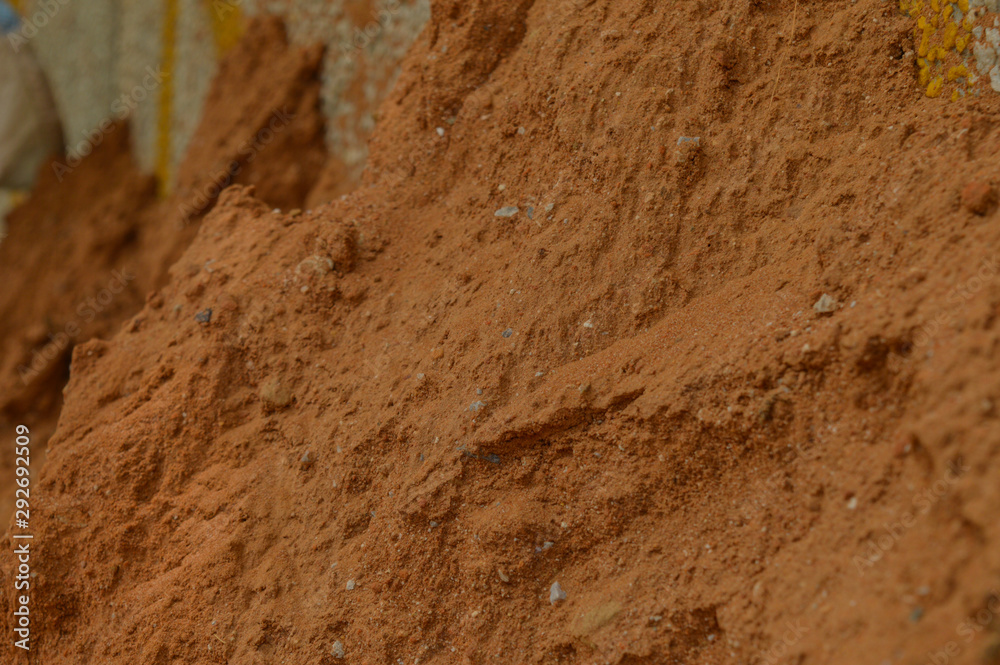 A small sand mountain on the side of road in polluted city, micro shot.