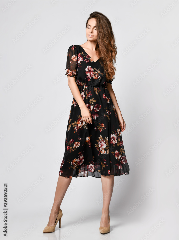 Slim curly female model in a silk dress looking at the camera in full growth. Cute girl in romantic clothes is going on a date Slim curly female model in a silk dress looking at the camera in full growth. Cute girl in romantic clothes is going on a date