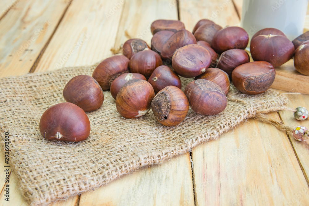Delicious roasted chestnuts on wood background Delicious roasted chestnuts on wood background