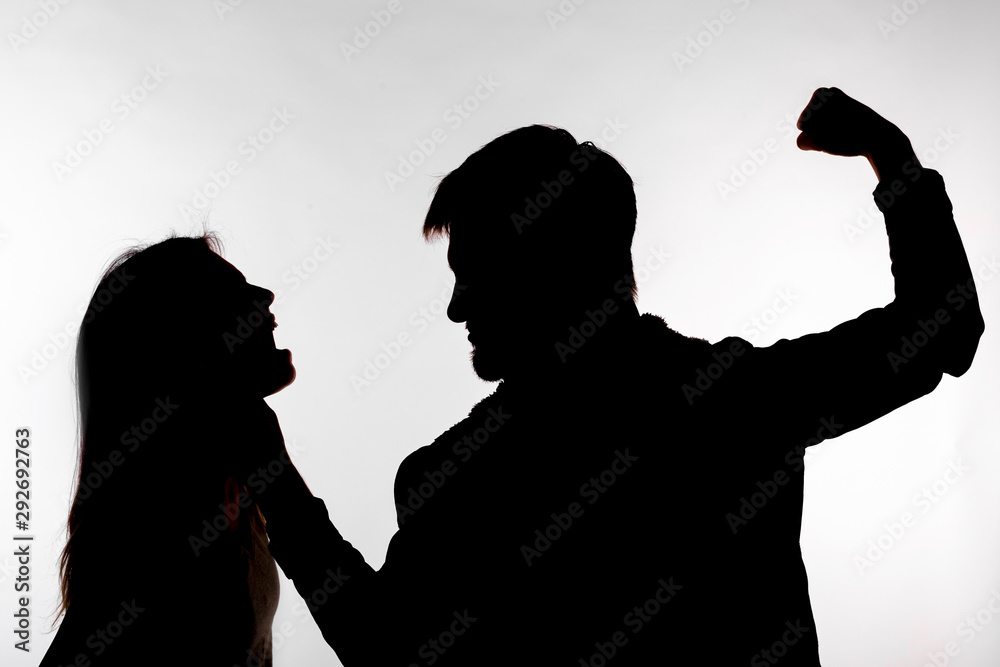 Domestic violence and abuse concept - Silhouette of man beating defenseless woman
