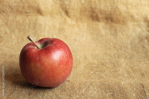  Red apple on a light brown background. Free place.