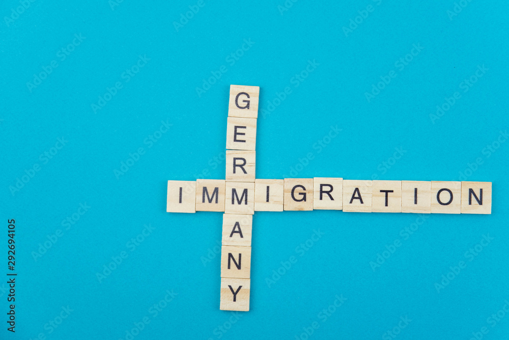 Immigration minimalistic concept. Isolated wooden letter blocks with word cloud Immigration to Germany