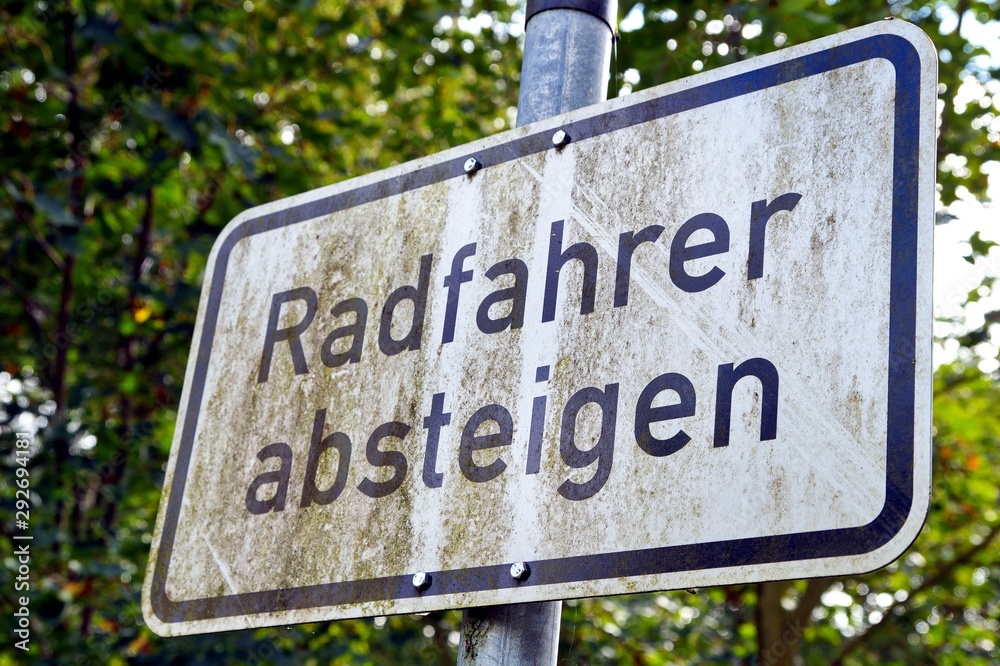 Sign cycling and bike. Cyclists please descend. dirty German road sign - Radfahrer bitte absteigen - for cyclists to dismount of their bike Sign cycling and bike. Cyclists please descend. dirty German road sign - Radfahrer bitte absteigen - for cyclists to dismount of their bike