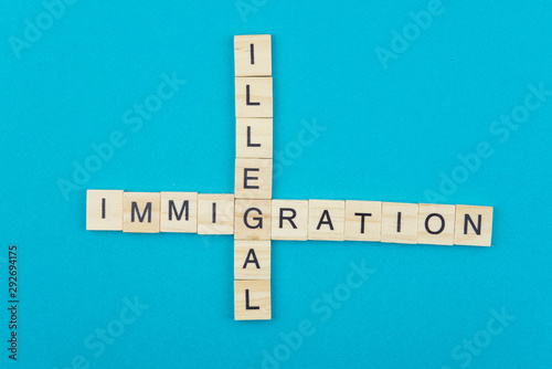 Immigration minimalistic concept. Isolated wooden letter blocks with word cloud Illegal Immigration