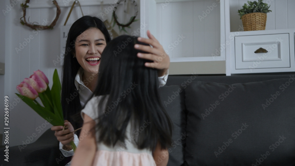 Holiday concept. The daughter is bringing flowers to surprise her mother's birthday. 4k Resolution.