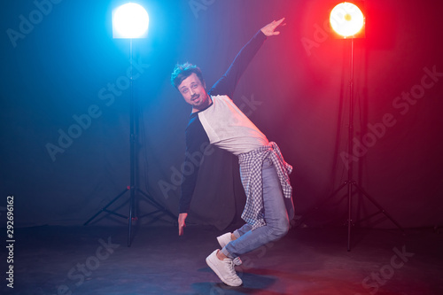 Dance  hip-hop and reggaeton concept - young man dancing over the lights.
