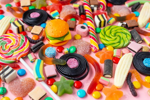 multicolored caramel candies and fruit bonbon on pink background