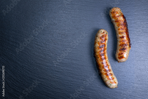 top view of grilled sausages on black slate, copy space