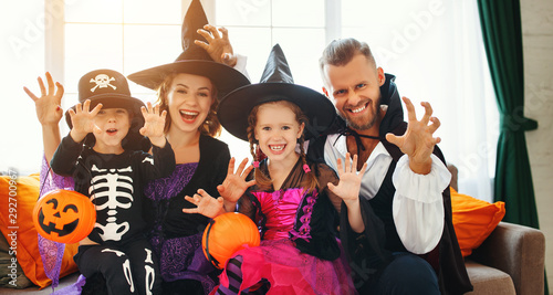 happy family mother father and children in costumes on Halloween.