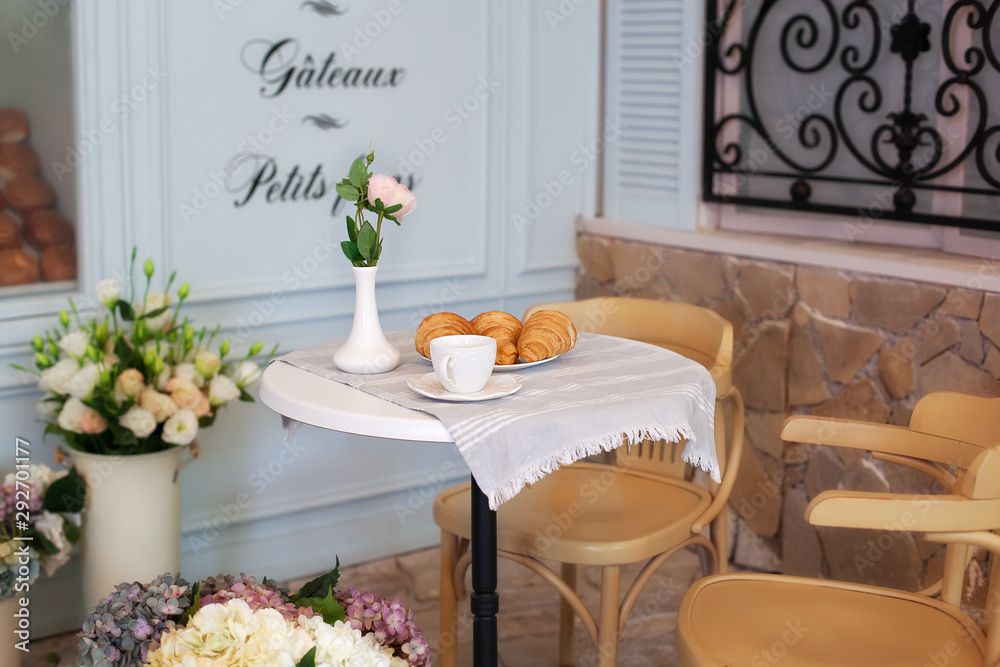 Tasty breakfast cup of coffee with croissants near bakery in morning. Continental traditional breakfast. Breakfast at street cafe. Good morning. Morning coffee on the terrace. Breakfast outside. decor Tasty breakfast cup of coffee with croissants near bakery in morning. Continental traditional breakfast. Breakfast at street cafe. Good morning. Morning coffee on the terrace. Breakfast outside. decor