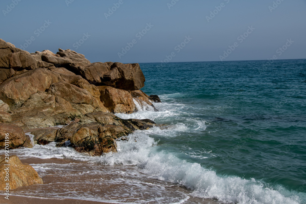 Die Wellen brechen sich an den Felsen