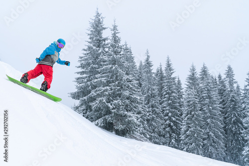 Snowboarder rides from powder snow hill. Mountain freeride snowboarding. Winter Carpathians
