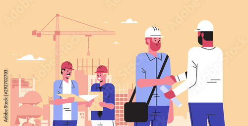 builders team shaking hands during meeting mix race engineers workers in helmet discussing new project on blueprint handshake agreement concept construction site background portrait horizontal