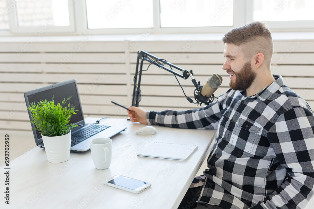 Radio host concept - Side view of handsome man working as radio host at radio station Radio host concept - Side view of handsome man working as radio host at radio station