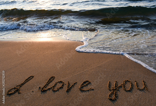 The inscription on the sand love you.