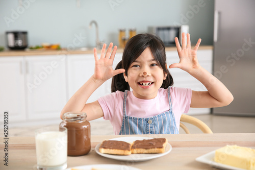 Funny little girl eating ta...