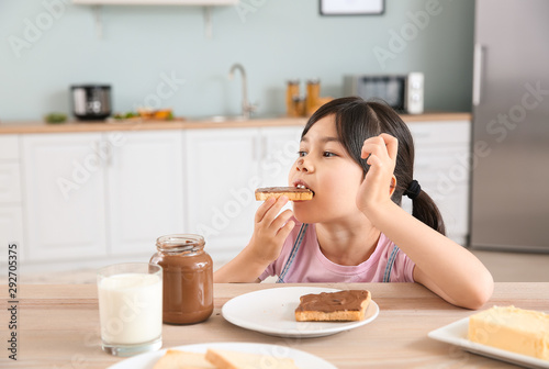 Funny little girl eating ta...