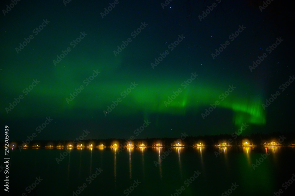 Northern light Aurora borealis iluminated under the starry dark  sky and water reflection from lake