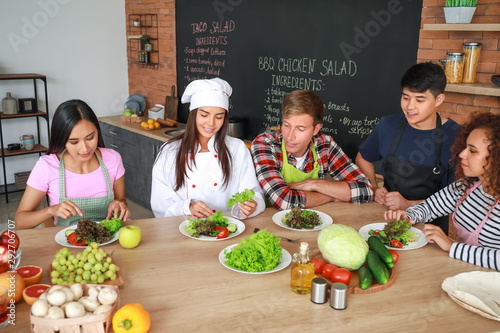 Female chef and group of yo...