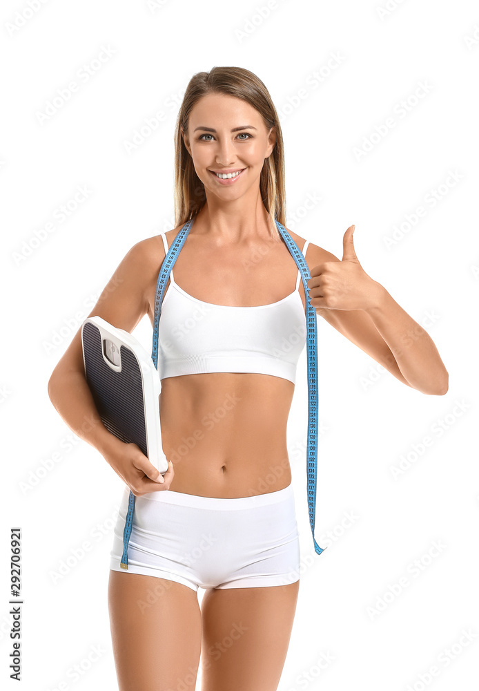 Beautiful young woman with measuring tape and scales showing thumb-up on white background. Weight loss concept Beautiful young woman with measuring tape and scales showing thumb-up on white background. Weight loss concept