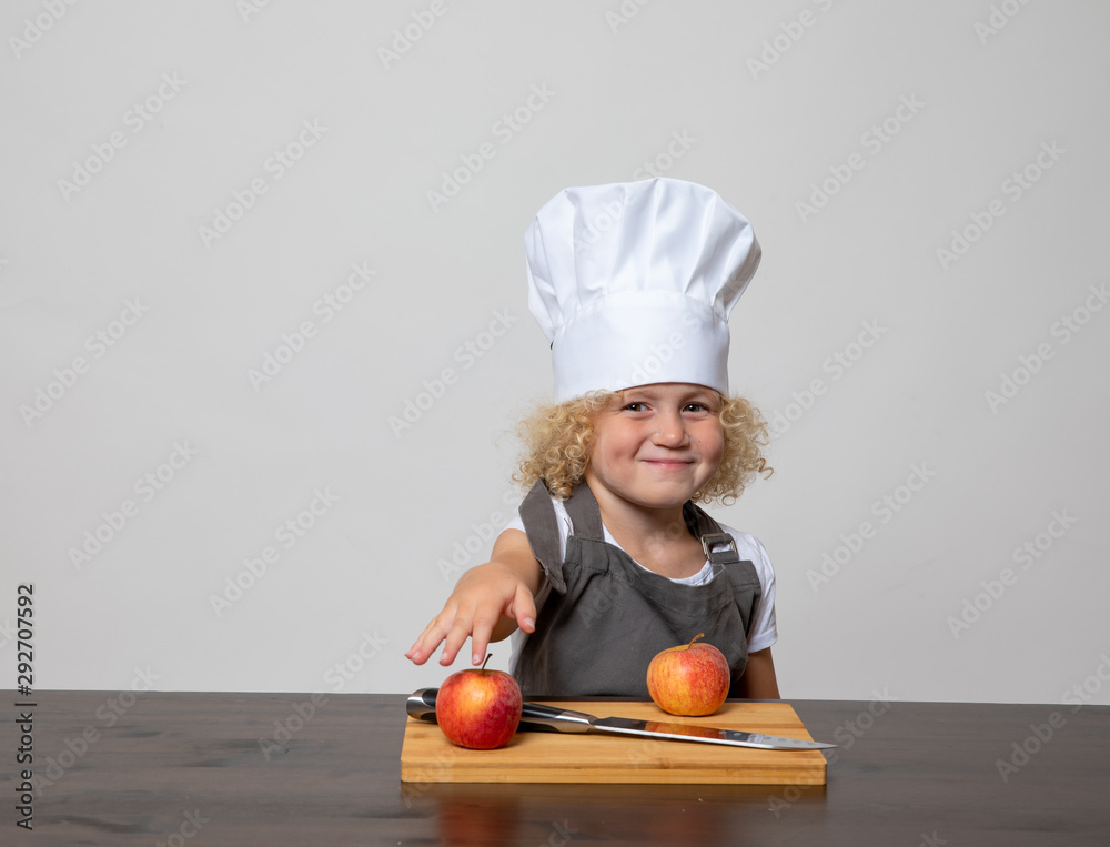 little girl with chefs hat, knife, and apples little girl with chefs hat, knife, and apples