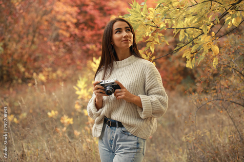 Woman photographer take a photo walking in the autumn forest