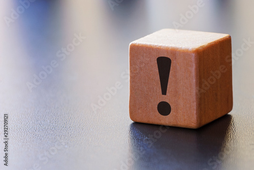 Warning exclamation mark on a wooden block