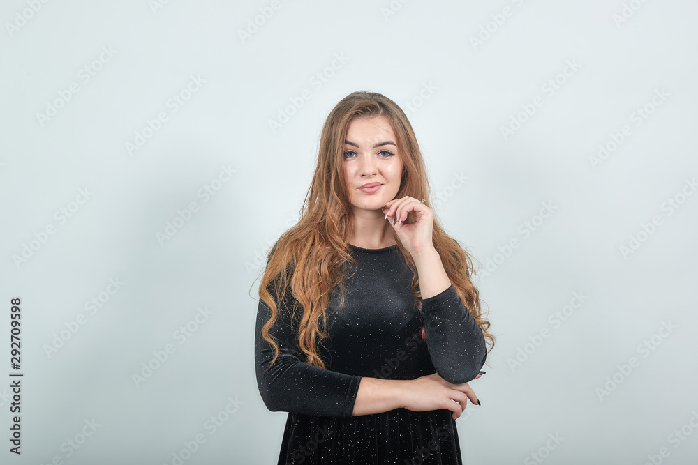girl brown haired in black dress over isolated white background shows emotions girl brown haired in black dress over isolated white background shows emotions