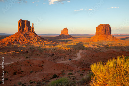 Monument Valley is a region of the Colorado Plateau characterized by a cluster of vast sandstone buttes  the largest reaching above the valley floor. It is located on the Arizona-Utah border. Tourism