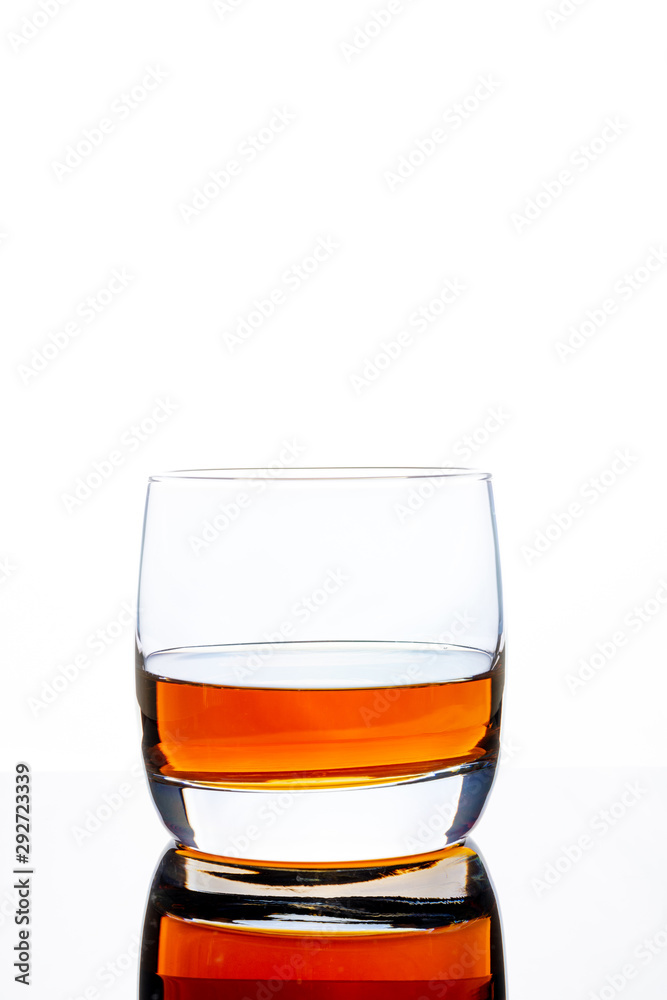 Glass of whiskey on a white background. White background. Whiskey / Brandy / Cognac / Rum. Glass with a strong drink. Glass of whiskey on a white background. White background. Whiskey / Brandy / Cognac / Rum. Glass with a strong drink.