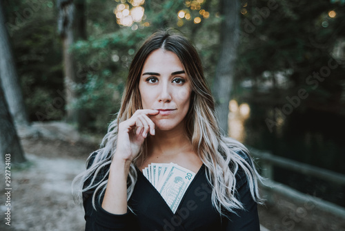 Woman with some dollar bills inside her cleavage, concept of male chauvinism, added film grain. photo