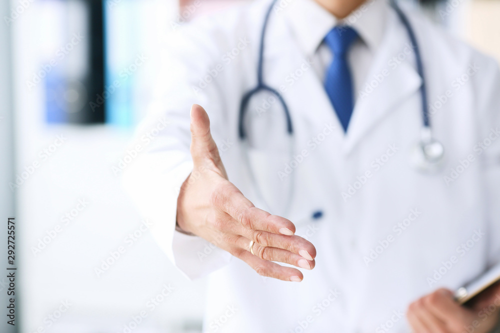 Close-up of clipboard with blank paper in medical doctor hand. Male doctor listens to the patient holding a clipboard with documents for hospitalization. Close-up of clipboard with blank paper in medical doctor hand. Male doctor listens to the patient holding a clipboard with documents for hospitalization.