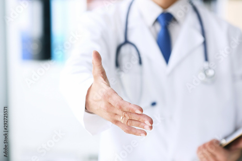 Close-up of clipboard with blank paper in medical doctor hand. Male doctor listens to the patient holding a clipboard with documents for hospitalization.