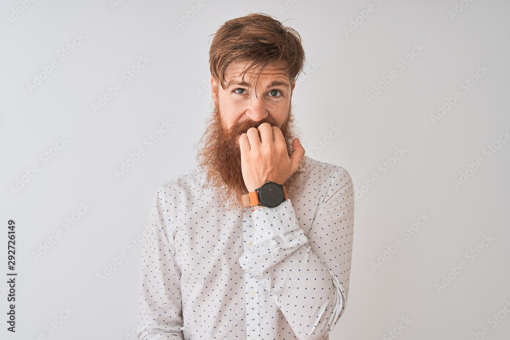 Young redhead irish man wearing shirt standing over isolated white background looking stressed and nervous with hands on mouth biting nails. Anxiety problem. Young redhead irish man wearing shirt standing over isolated white background looking stressed and nervous with hands on mouth biting nails. Anxiety problem.