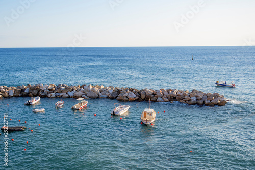 Several boats, stones, blue sea and sky photo