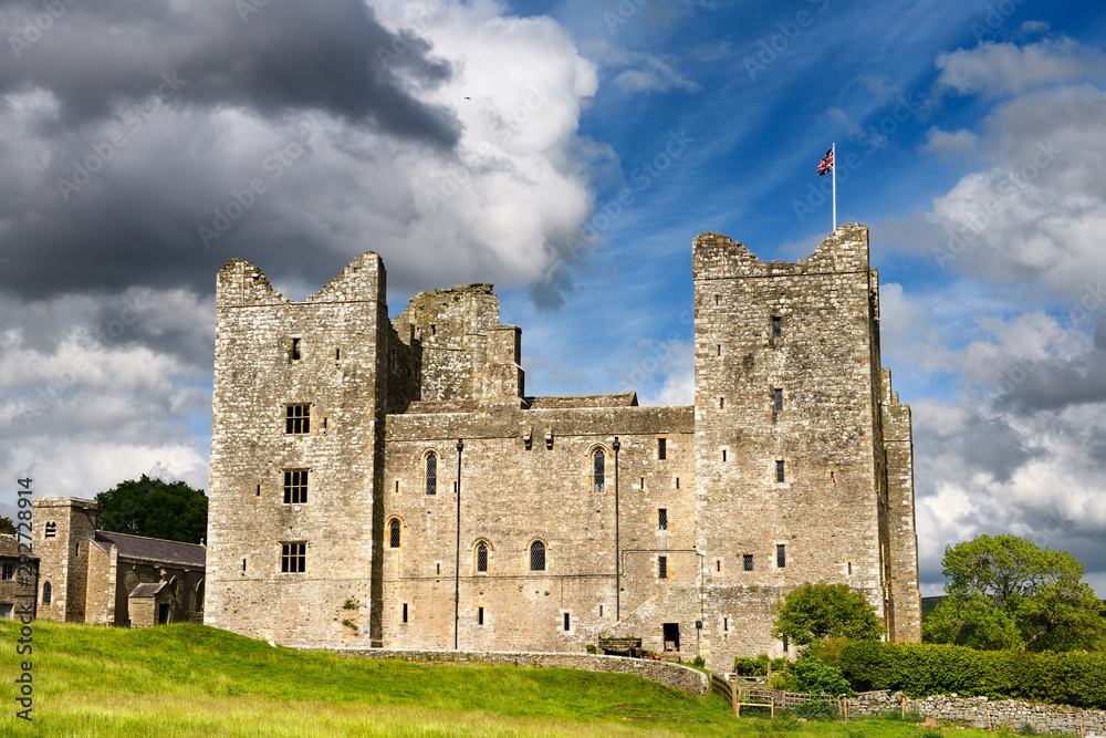 West side of 14th-century Bolton Castle in sun with British flag Wensleydale Yorkshire England