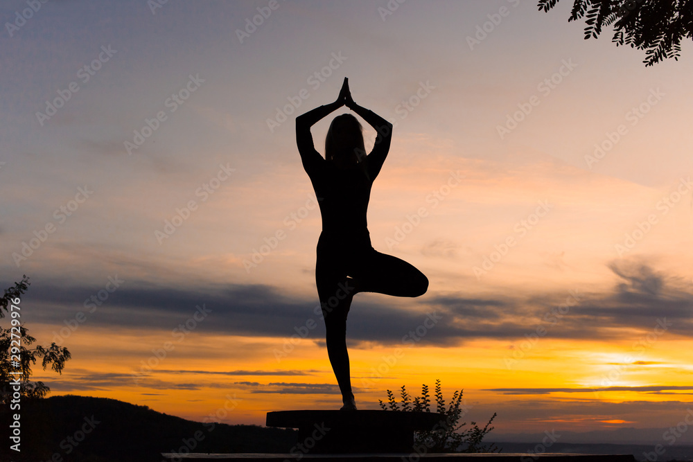 Silhouette woman coach yoga practice at sunset. Vrikshasana. Tree Pose