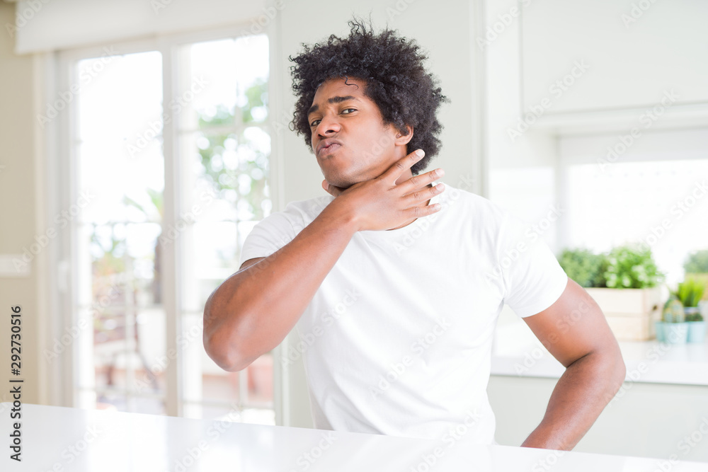 Young african american man wearing casual white t-shirt sitting at home cutting throat with hand as knife, threaten aggression with furious violence Young african american man wearing casual white t-shirt sitting at home cutting throat with hand as knife, threaten aggression with furious violence